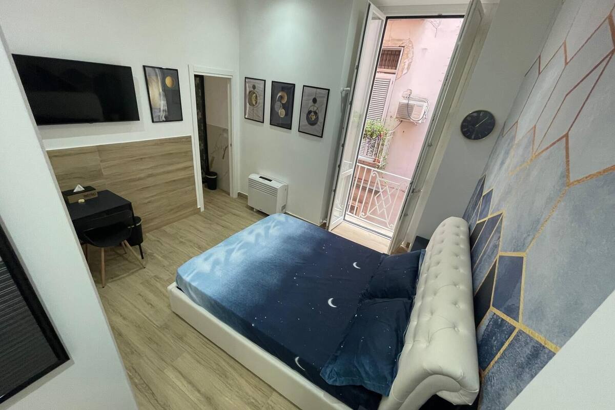 Une chambre à coucher avec un lit, un bureau et un téléviseur.