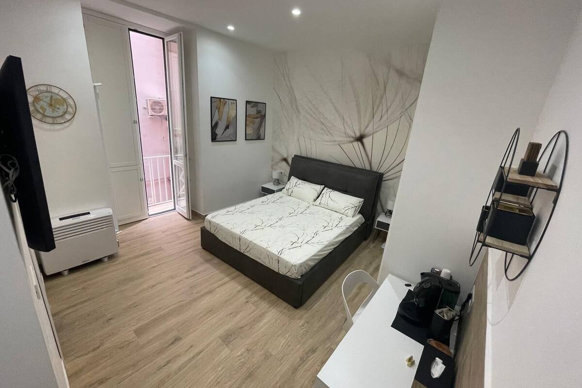 Une chambre à coucher moderne avec un lit, une table de chevet et un bureau.