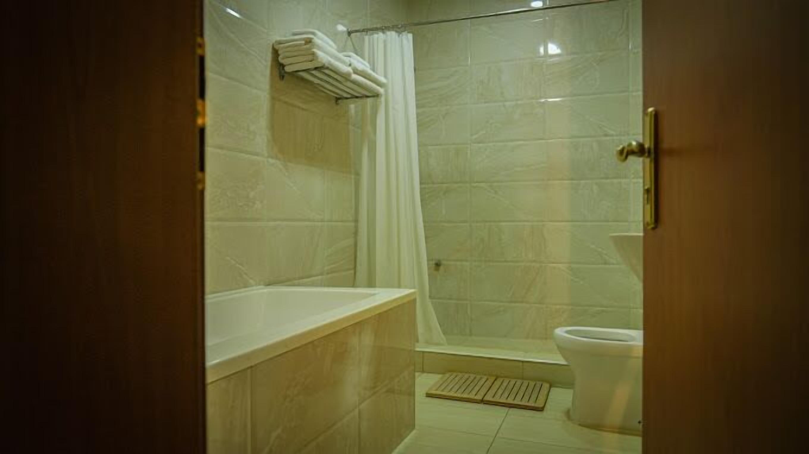 A bathroom with a bathtub, shower, and toilet.