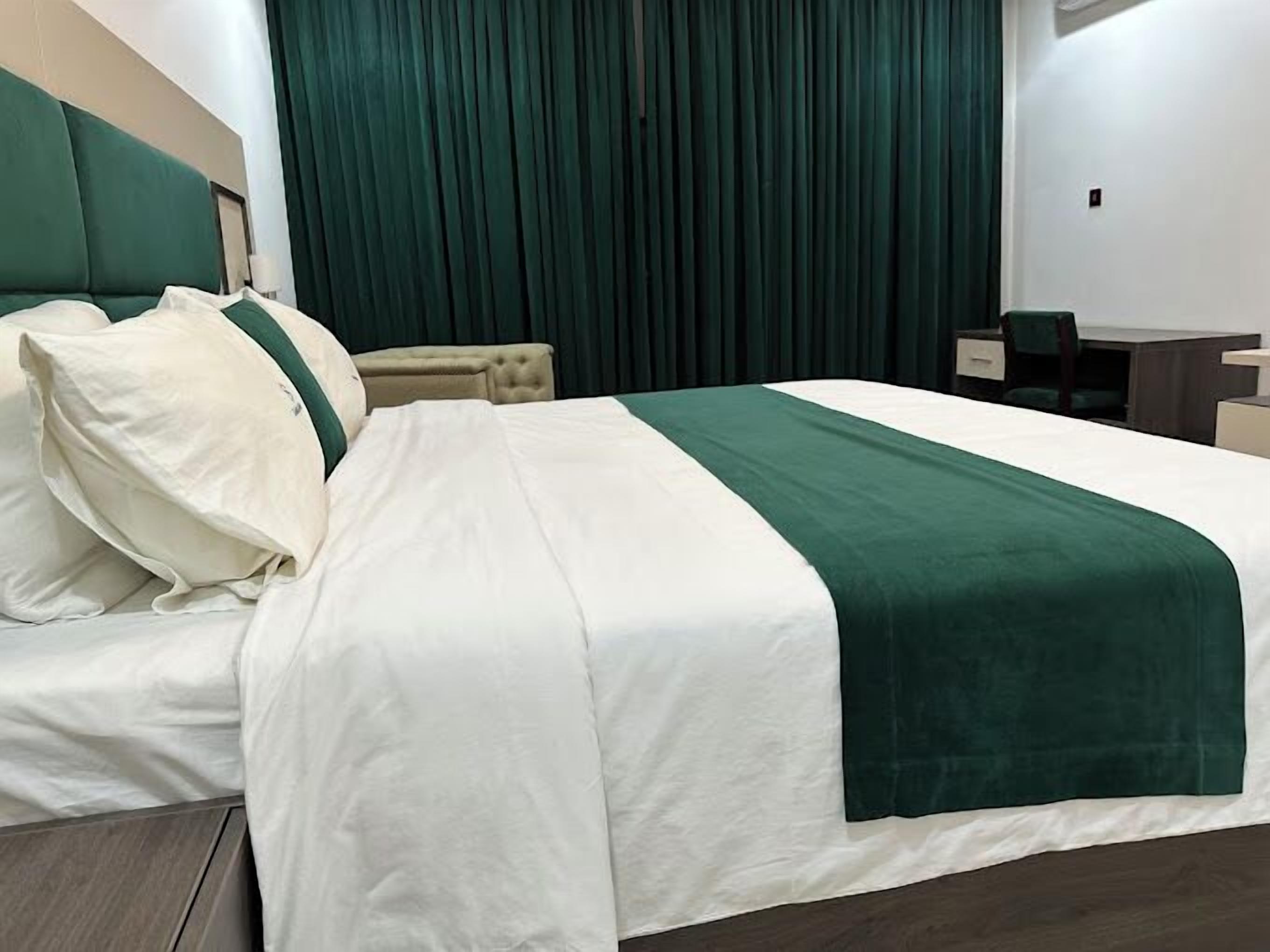 Una habitación de hotel con una cama grande, un escritorio y una silla.