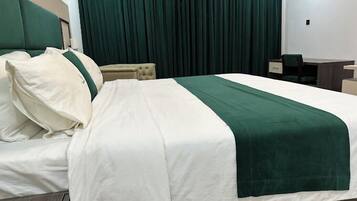 Una habitación de hotel con una cama grande, un escritorio y una silla.