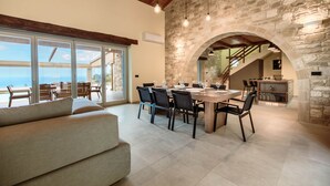 Un comedor espacioso con un arco de piedra, una gran mesa dispuesta para comer y vistas al exterior.