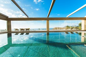 A modern infinity pool with clear water, lounge chairs, and a view of the ocean and mountains. - Villa Kalithea, with indoor heating pool, unlimited sunset views to the ocean. (KISSAMOS)