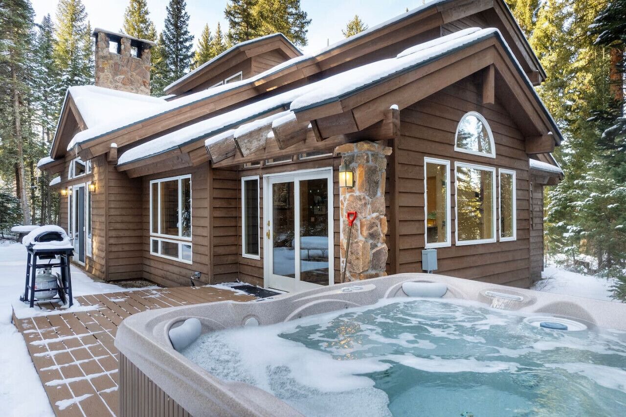 Eine Blockhütte mit Whirlpool und einem Steinkamin.
