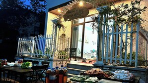 Un buffet en plein air est installé dans un restaurant, avec une variété de plats présentés sur des tables.