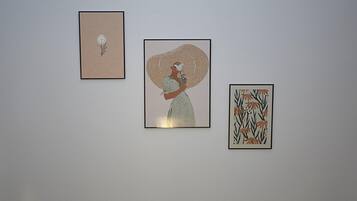 Three framed artworks on a plain wall.