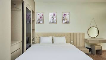 A bedroom with a bed, a bedside table, a hanging mirror, and three wall-mounted artworks.