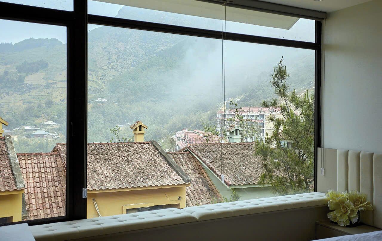 Une pièce dotée d’une grande fenêtre donnant sur un paysage montagneux.