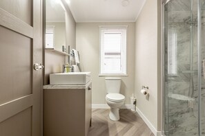 A bathroom with a toilet, sink, and shower. - Lodge No 85 | Hot Tub | Stewart's Resort Cameron (Cameron)