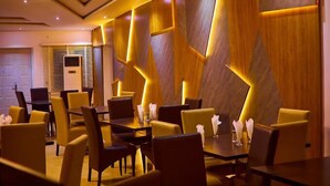 Un espace de restauration moderne, avec des motifs géométriques sur les murs et des chaises jaunes.