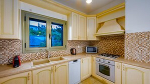 A compact kitchen with a sink, stove, microwave, and dishwasher. - Villa Inna With 3 Bedrooms and 4 Bathrooms (Lefkada)