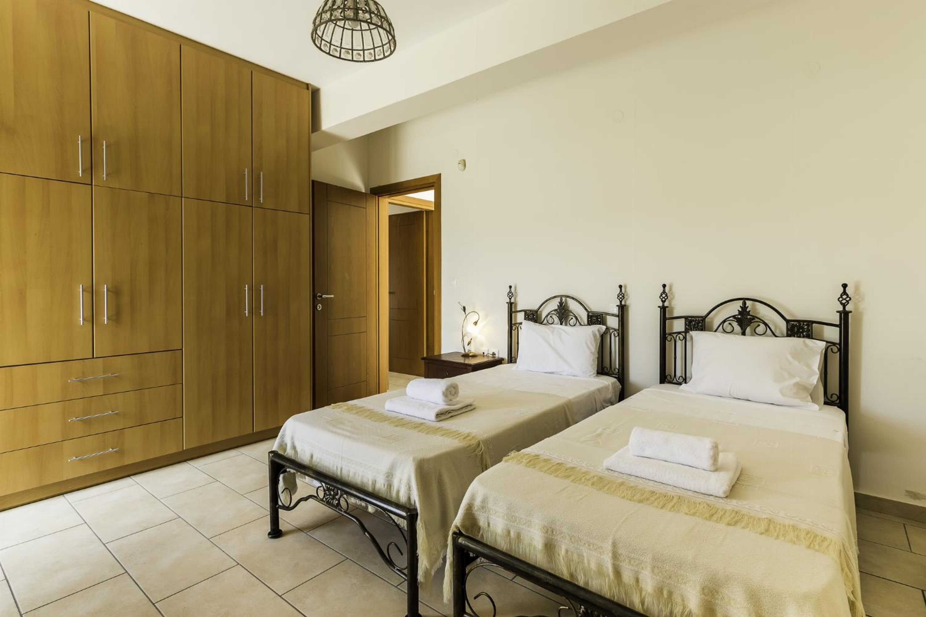 Une chambre avec deux lits, une armoire et une table de chevet.