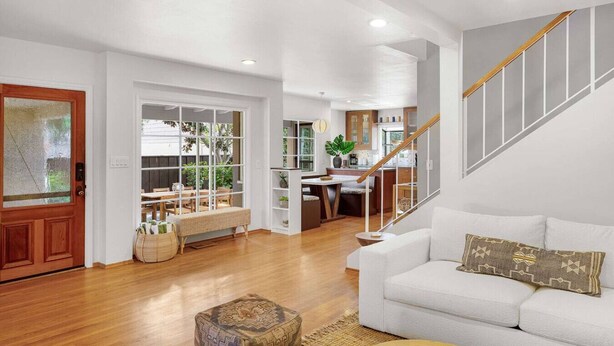 A spacious living area with a staircase, a dining area, and a kitchen. - The OB Hideaway, pool, hot tub (San Diego)