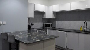 A modern kitchen with a marble island, grey cabinets, a microwave, and a sink. - 2bed Apt Sleeps 4-near Meadows Park, Parking, Wifi (Edinburgh)