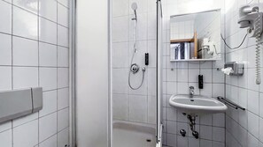 A modern bathroom with a shower, sink, and a mirror. - Comfortable and versatile room -perfect for relaxation, work and exchange (Winterberg)