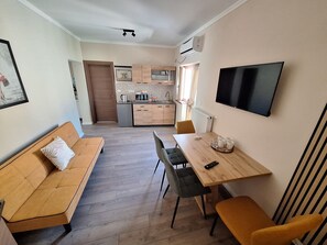 Superior appartement, uitzicht op tuin | Woonruimte | Televisie