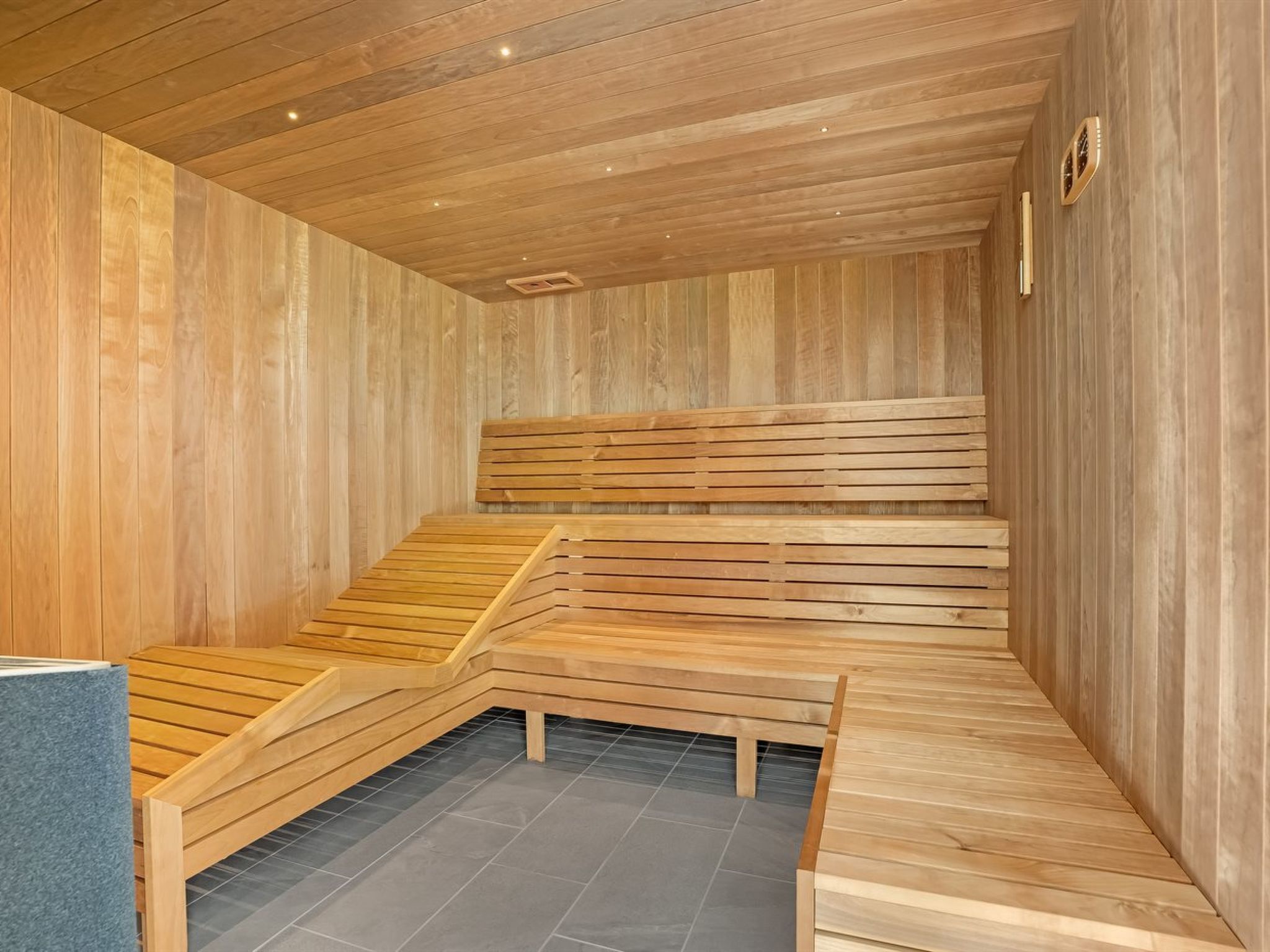 A sauna with wooden benches and a tiled floor.