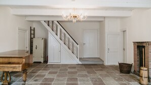 Ein geräumiger Flur mit Treppe, einer Deckenleuchte und einem Kamin.