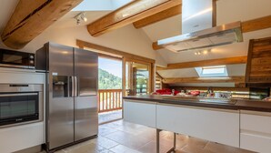 A modern kitchen with stainless steel appliances, a wooden ceiling, and a view of the outdoors. - Beautiful apartment for 6 people at Grand-Bornand with parking (Le Grand-Bornand)