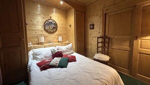 Una habitación acogedora de madera con una cama, dos mesitas de noche y un cuadro colgado en la pared.