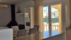Una cocina moderna con encimeras de granito, horno empotrado y comedor con mesa y sillas.