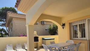 An outdoor patio with a table and chairs, a barbecue grill, and a brick building in the background. - House in Riumar: Family Charm with Private Pool (Deltebre)