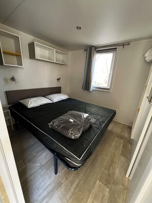 Cozy retreat with a single bed, shelves, and a window above.