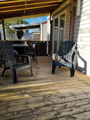 Relax on the covered deck with Adirondack chairs and a dining table.