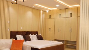 Un dormitorio moderno con una cama grande, un sofá y armarios empotrados de madera.