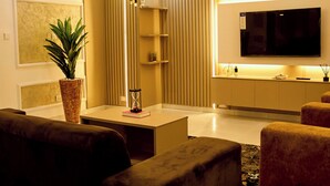 Una sala moderna con sofá, mesa de centro y televisor montado en la pared.