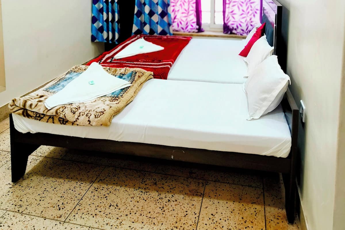 Ein Schlafzimmer mit Bett, Vorhängen, einer Klimaanlage und einem Deckenventilator.