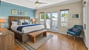 A bedroom with a bed, bench, chair, ceiling fan, and large windows. - Lovely home with backyard oasis & great WiFi - walk to La Jolla Village, dogs OK (La Jolla)