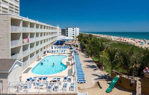 Um hotel com piscina, praia e vista para o oceano.