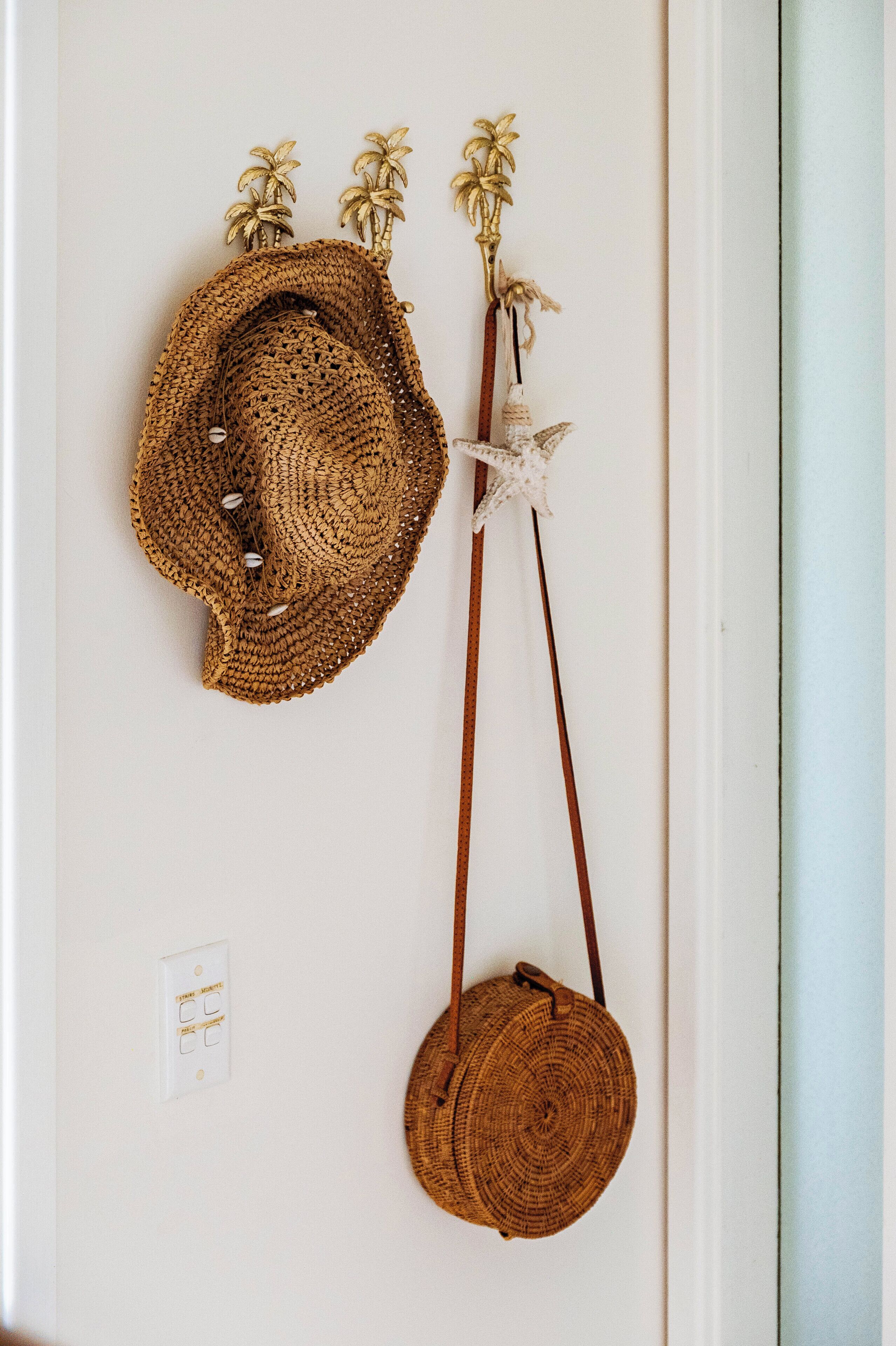 Ein an der Wand befestigter Hut und eine gewebte Tasche.