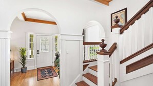 A staircase with wooden steps and white railings, leading to an upper floor.