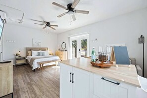 Un dormitorio con cama, mesitas de noche, un ventanal y vistas al exterior.