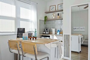 Una cocina moderna con comedor, un cartel y vistas al salón.