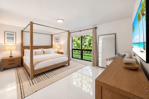 Une chambre moderne avec un lit à baldaquin, une grande fenêtre donnant sur un paysage verdoyant, un bureau en bois et un téléviseur à écran plat.