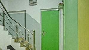 A staircase with metal railings leading to a green door. - Via Ganga View (Varanasi)