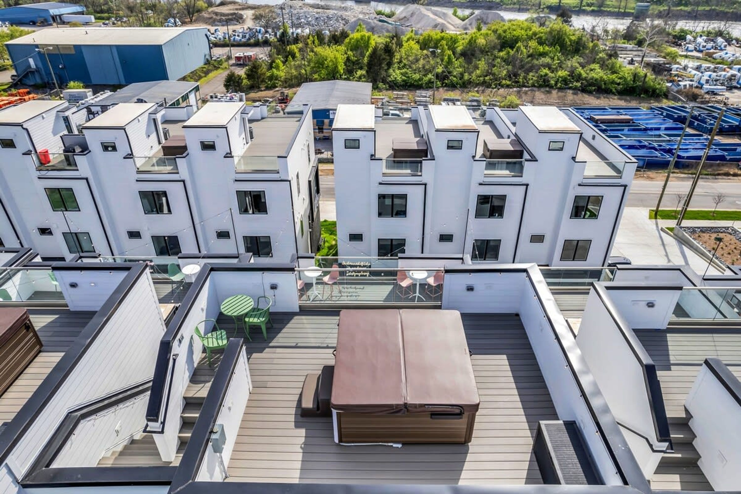 A modern apartment building with multiple balconies and a rooftop terrace.