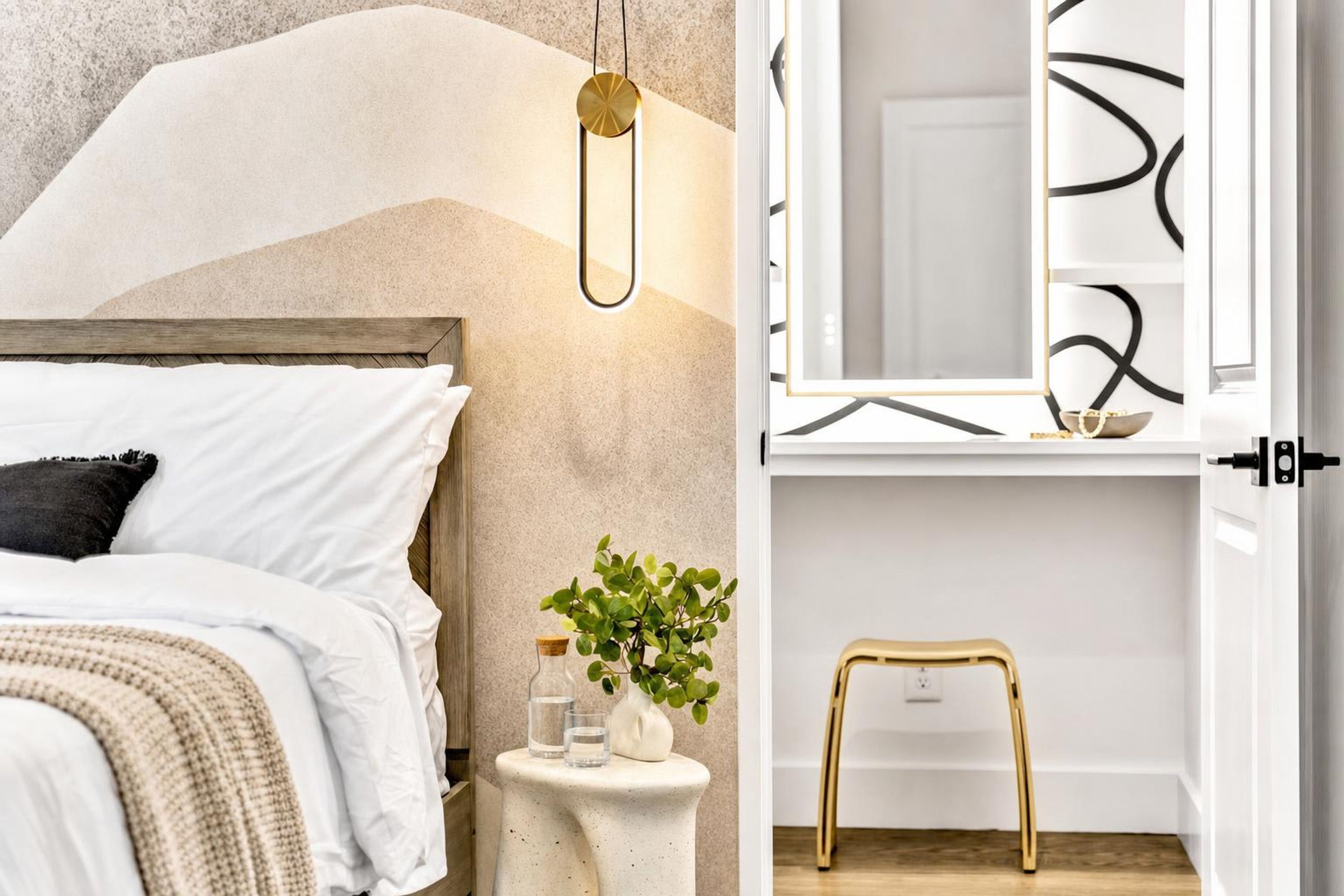 Une chambre à coucher avec un lit, une table de chevet et un miroir.