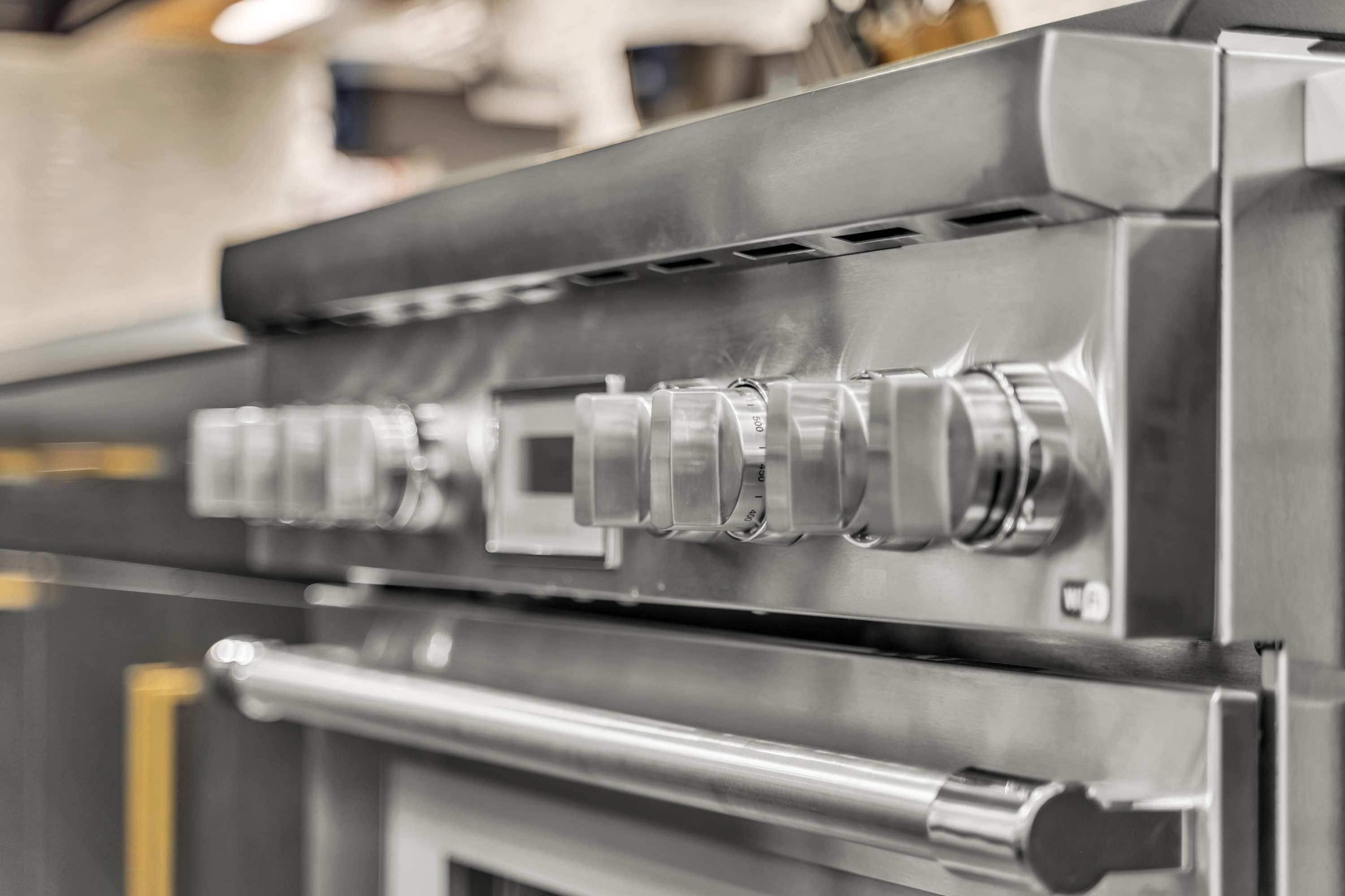 Une hotte de cuisine en acier inoxydable, dotée de plusieurs évents et d’un bouton de commande.