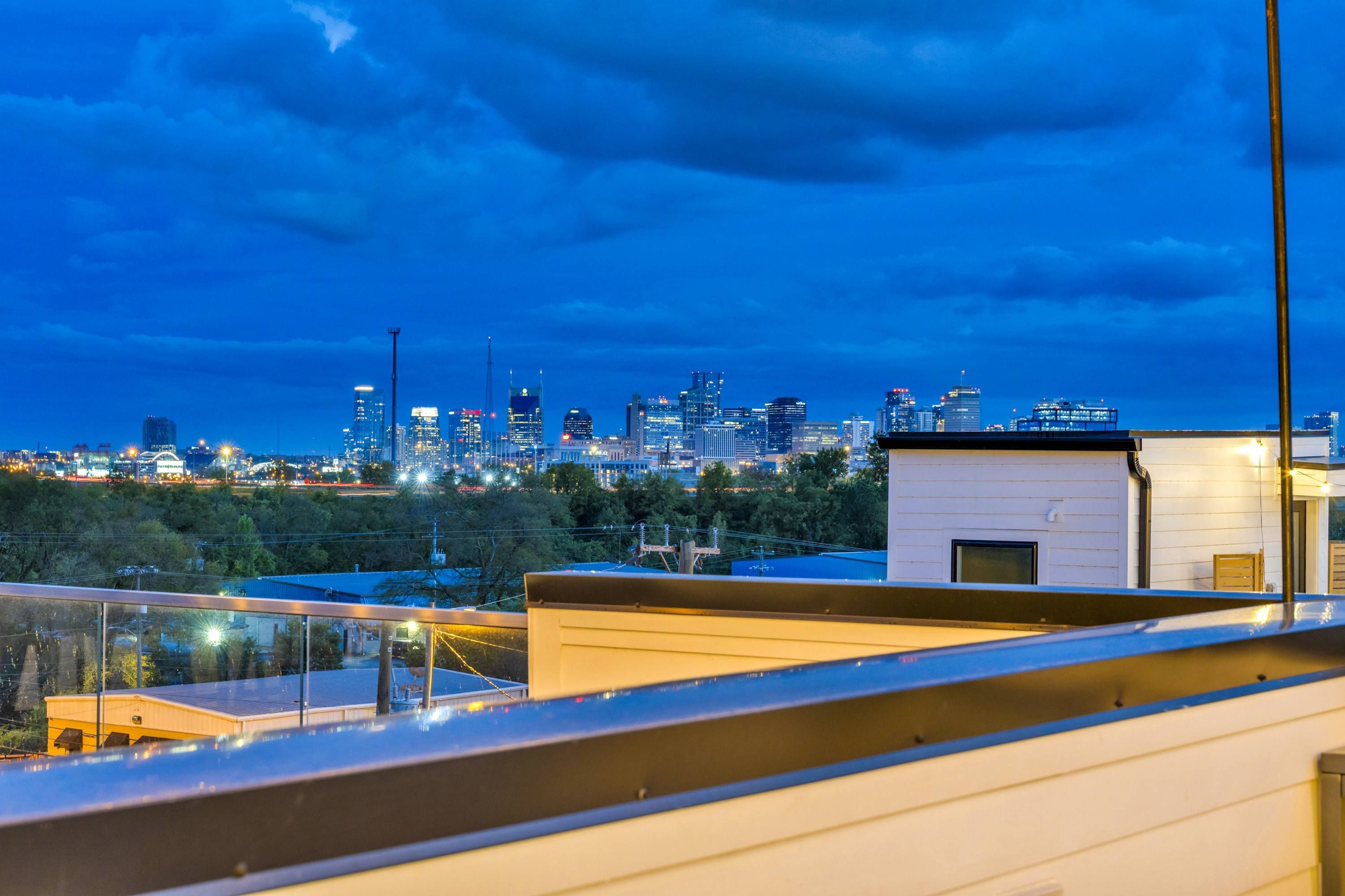 A city skyline at dusk with buildings illuminated against a dark sky.