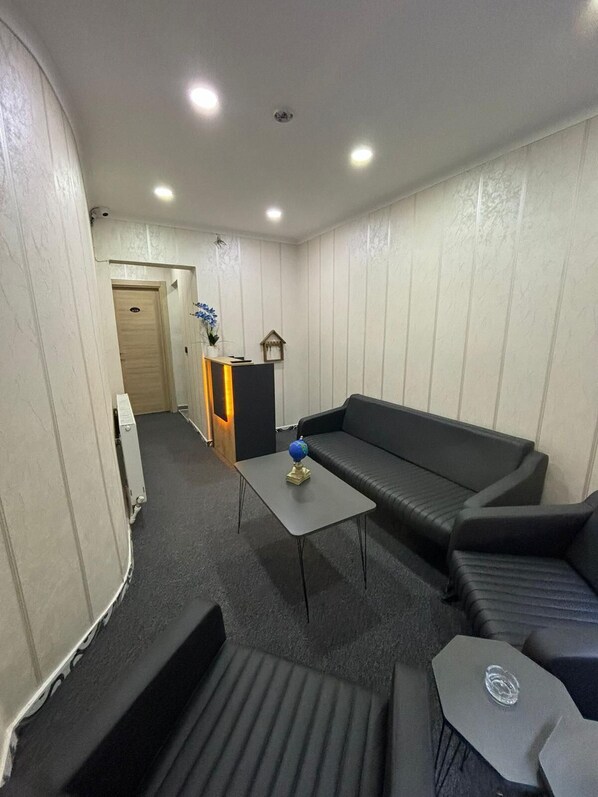 A compact living space with a sofa, a small table, and a radiator.