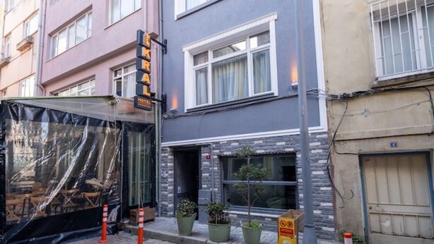 A hotel with a signboard, a construction site, and potted plants on the sidewalk. - Luxery Kral Hotel Beşiktaş (Istanbul)
