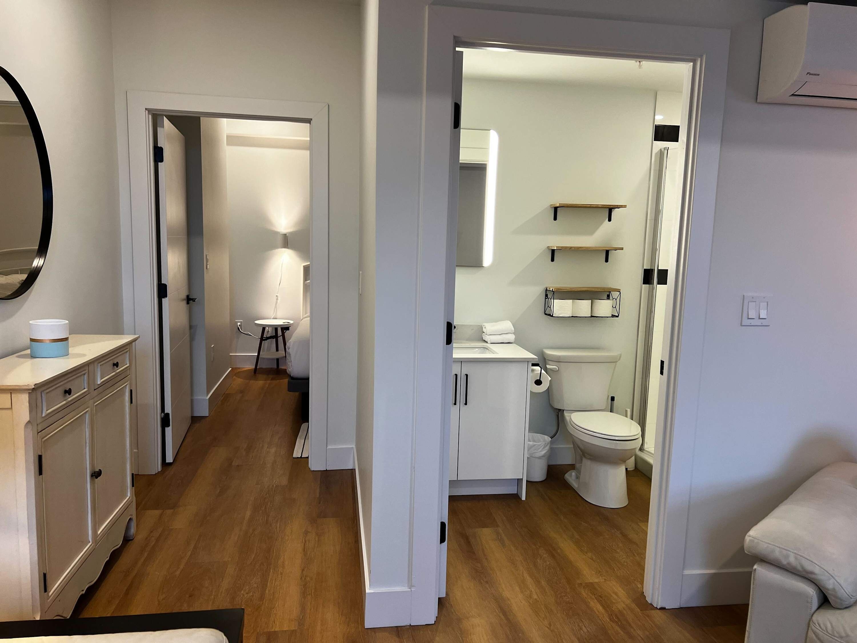 Une salle de bain moderne équipée de toilettes, d’un lavabo et d’étagères de rangement.