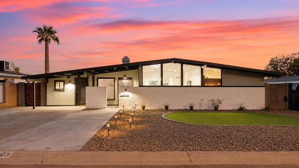 A modern house with a garage, a driveway, and a well-maintained lawn.