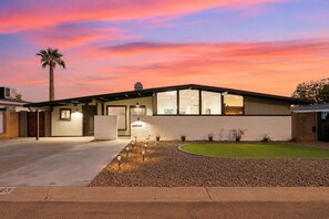 A modern house with a garage, a driveway, and a well-maintained lawn. - Pool & Games | Peaceful Neighborhood (Phoenix)