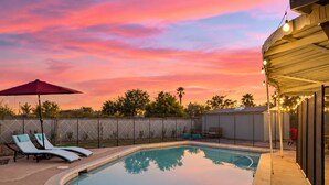 A swimming pool with lounge chairs and a covered patio area. - Pool & Games | Peaceful Neighborhood (Phoenix)