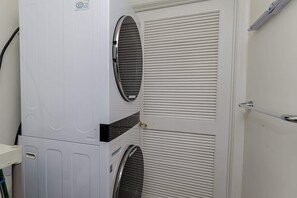 Paredes brancas com duas janelas e uma porta.